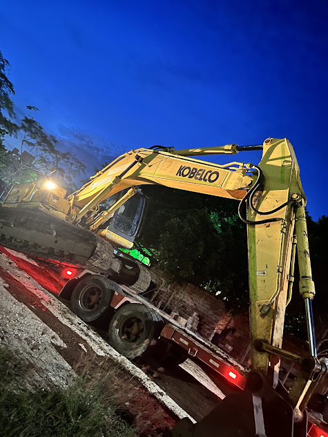 Excavadora Kobelco movilizada en cama baja durante la noche