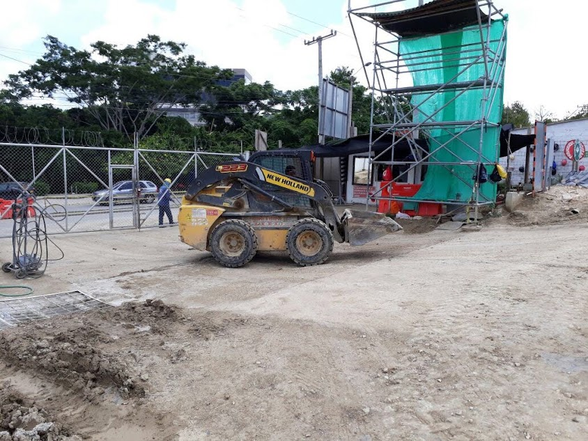 Minicargador New Holland apoyando un montaje de andamios